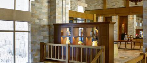 A spacious interior with a wooden staircase, stone walls, and a kitchen area with modern appliances.