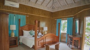 Een slaapkamer met houten lambrisering, een hemelbed, een bureau en een stoel.