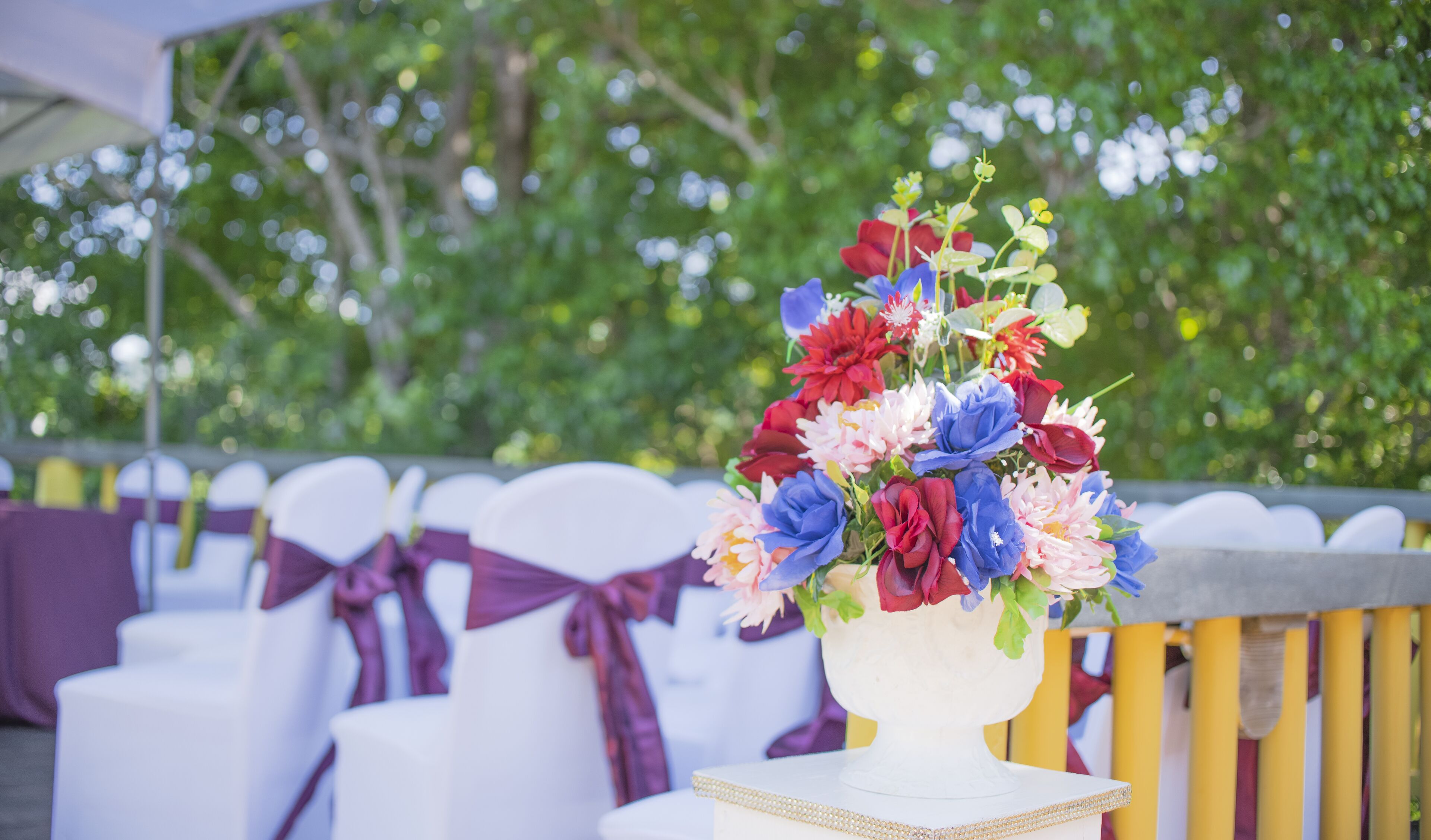 Un jarrón blanco con un arreglo floral sobre una mesa.