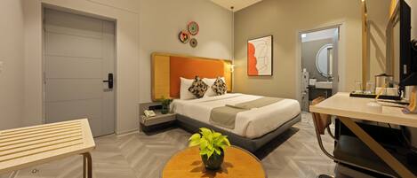 Una habitación de hotel moderna con cama, mesita de noche, escritorio, silla y una pequeña mesa con una planta.