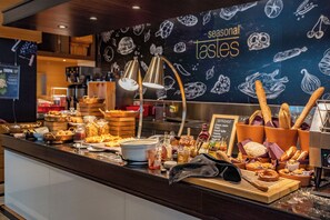 Mostrador de buffet con diversos alimentos y un letrero que dice 'sabores de temporada'.