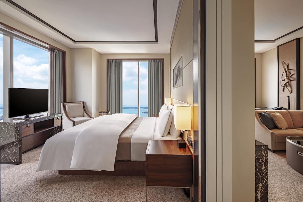 Une chambre d’hôtel avec un grand lit, une télévision, un bureau, une chaise et un canapé.