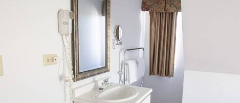 Ein typisches Hotelbad mit Toilette, Waschbecken und Spiegel.
