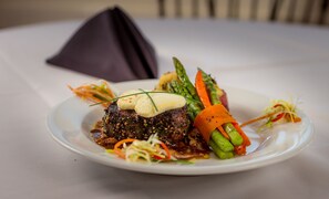 A plate of food with a steak, vegetables, and a dollop of sauce. - The Lucerne Inn (Holden)