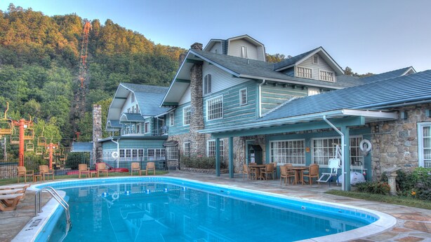 A pool area with a 'No Diving' sign, stone patio, and outdoor seating.