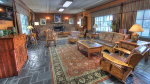 A cozy living room with a fireplace, comfortable seating, and a large rug.