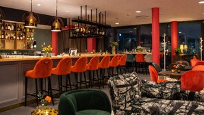 A bar area with multiple stools, a bar counter, and a seating area with chairs and a sofa. - Best Western Plus Park City Lund (Lund)