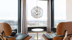 A modern room with two leather chairs, a round table, and a unique geometric pendant light. - Best Western Plus Park City Lund (Lund)