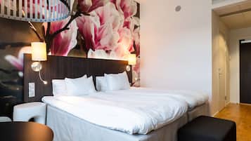 Habitación de hotel moderna con una cama grande, dos lámparas de noche, un espejo redondo y una lámpara empotrada en la pared.