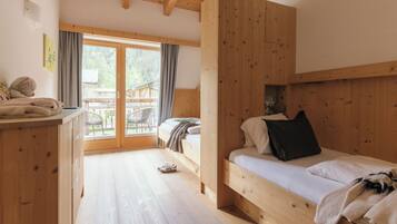 Habitación de cabaña de madera con literas, un escritorio y vistas al exterior.