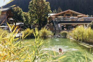 Una piscina techada, una piscina al aire libre, sombrillas