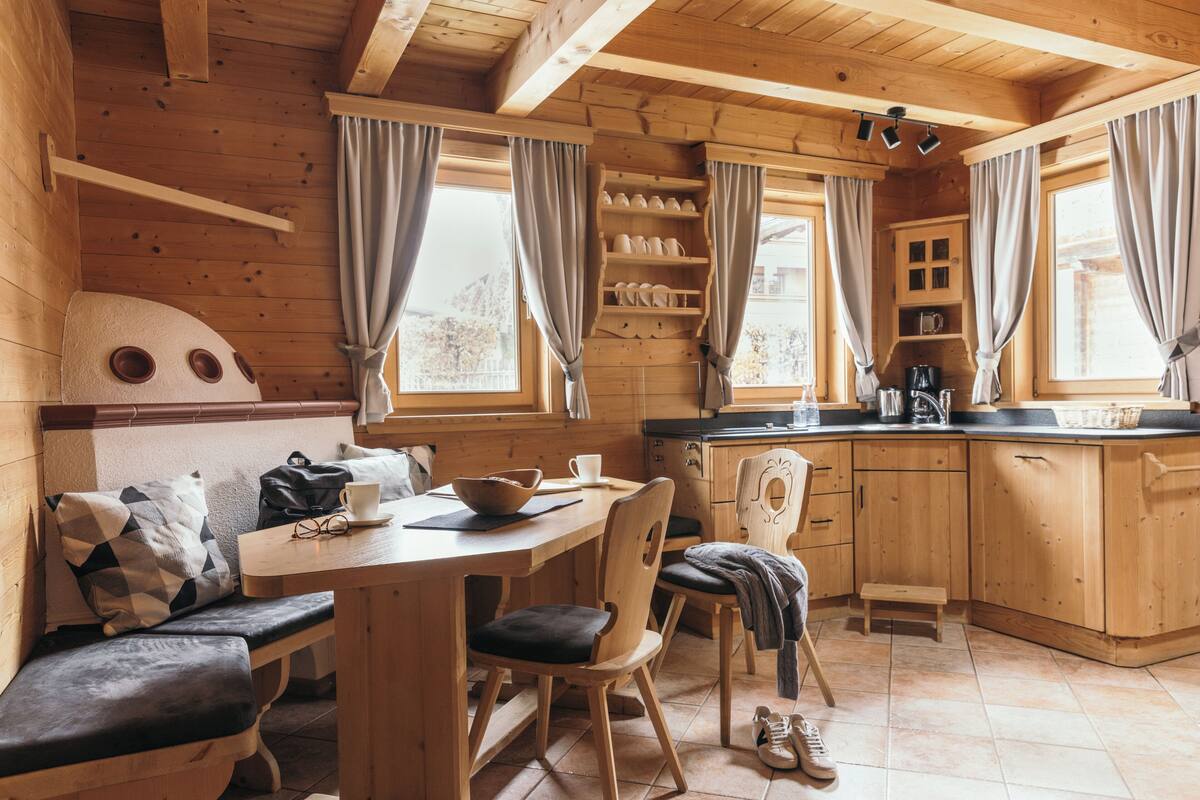 Een gezellig houten blokhut interieur met een eethoek, keuken en zithoek.
