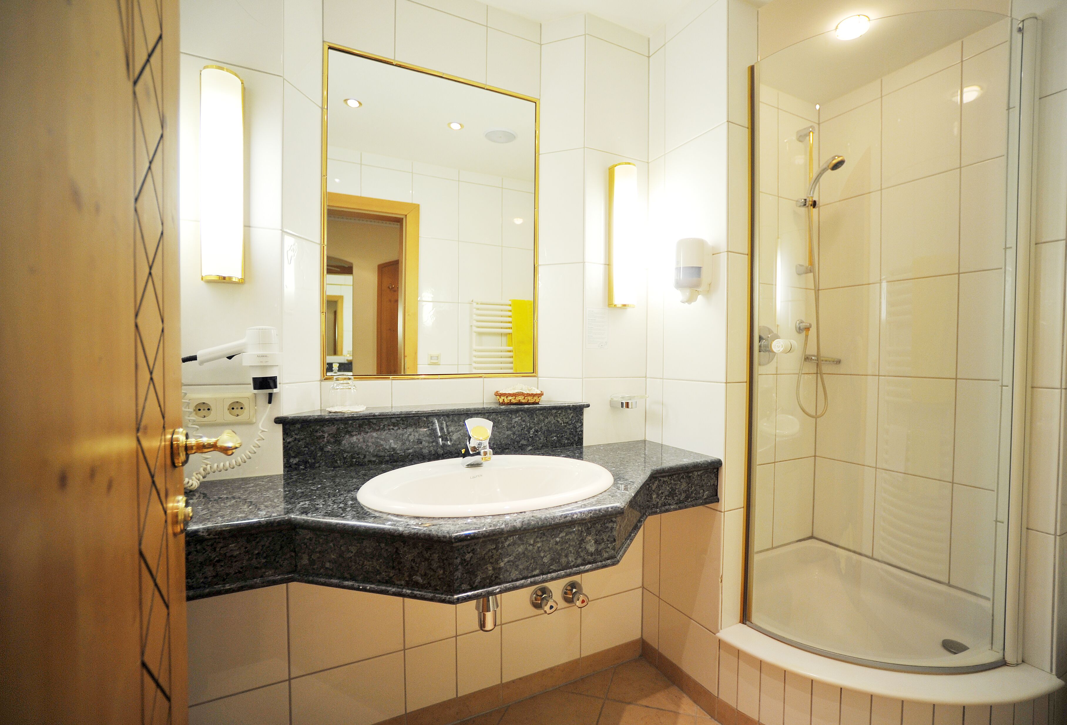 Une salle de bain avec un lavabo, un miroir et une douche.