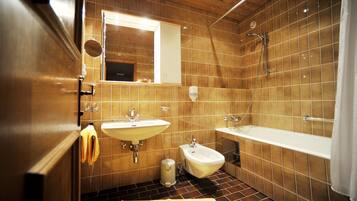 Un baño con techo de madera, dos lavamanos, un bidé y una ducha.