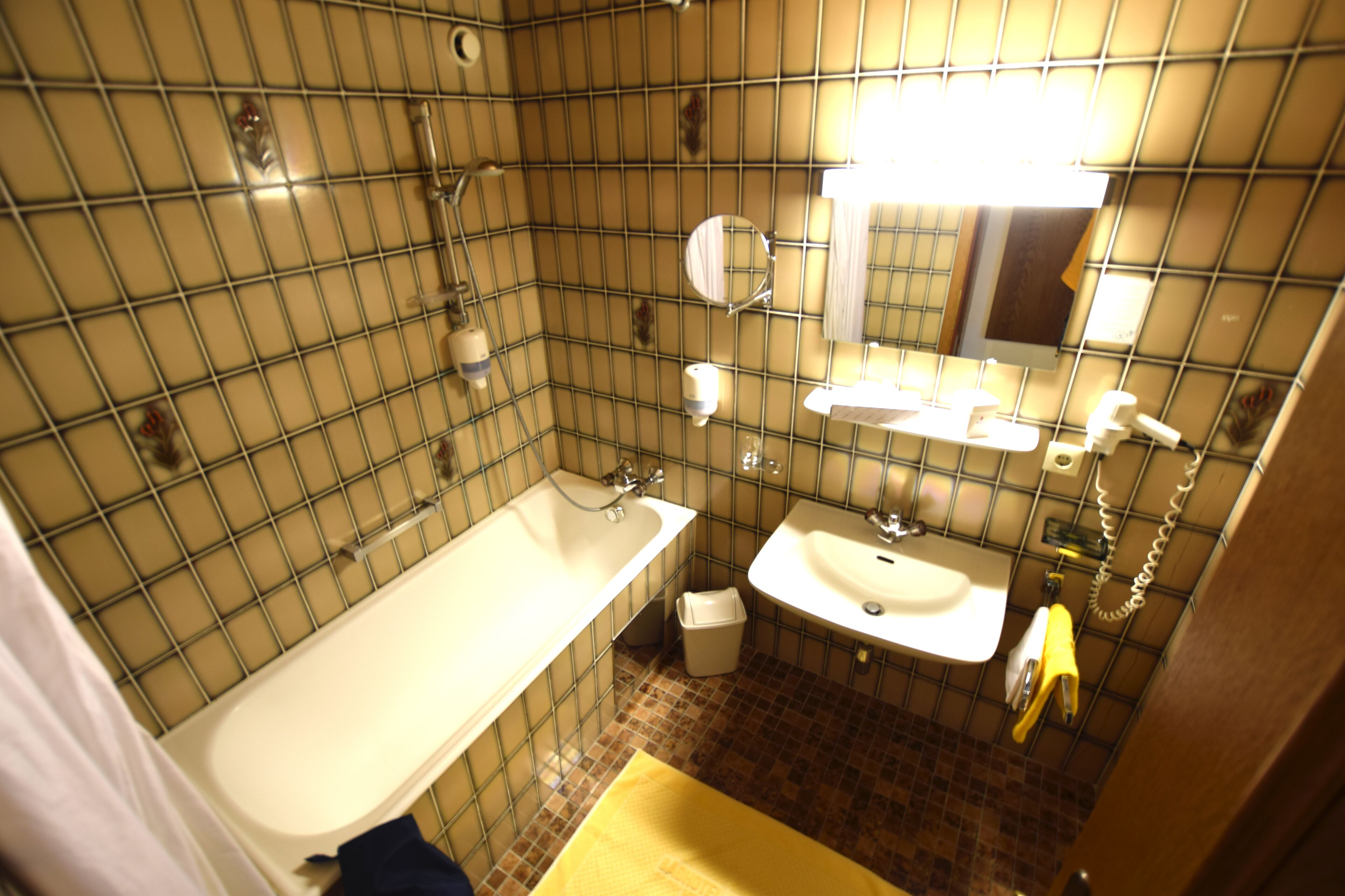 A bathroom with a bathtub, sink, and mirror.
