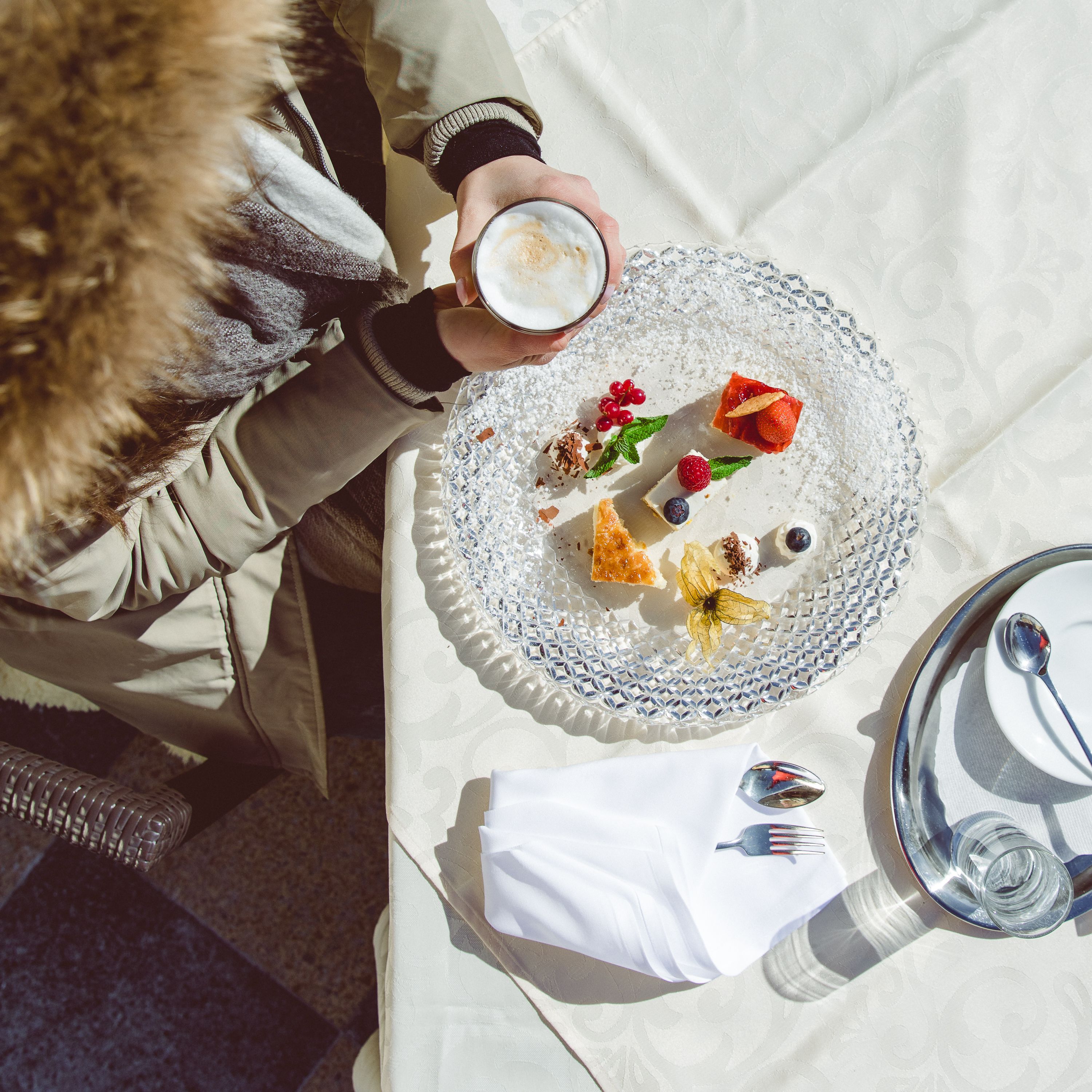 Ein Tisch mit einer Desserttellere, einer Kaffeetasse und einer Gabel.