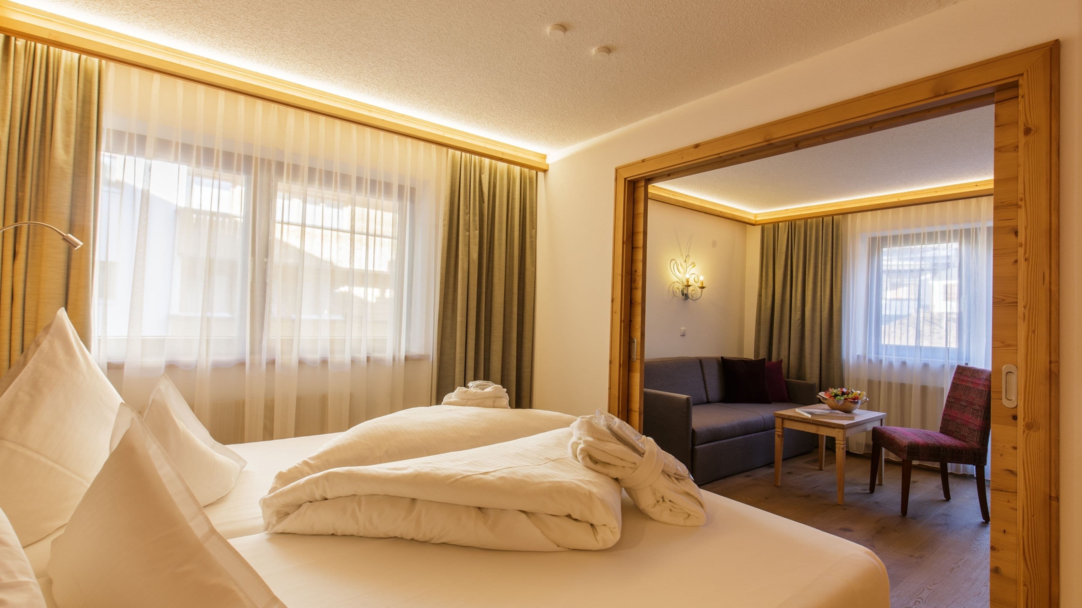 Una habitación de hotel con una cama grande, un escritorio, una silla y un sofá.