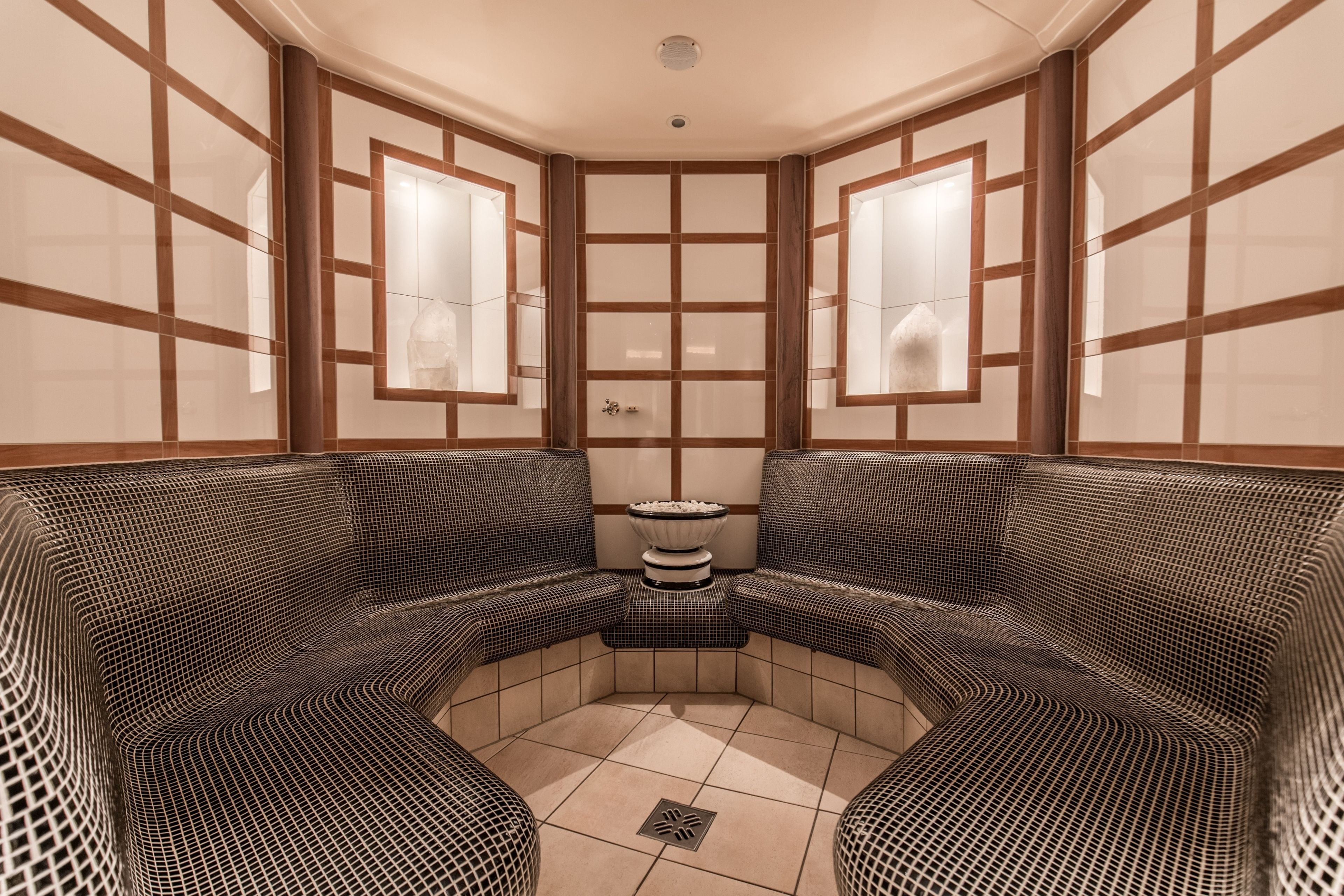 Una spa con una zona salotto ad arco, un tavolino con una ciotola e un pavimento piastrellato.