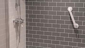 Un baño con ducha, bañera y pared de azulejos.