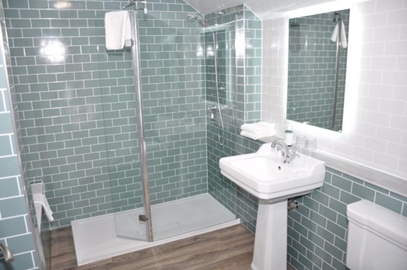 A bathroom with a shower, sink, and mirror.
