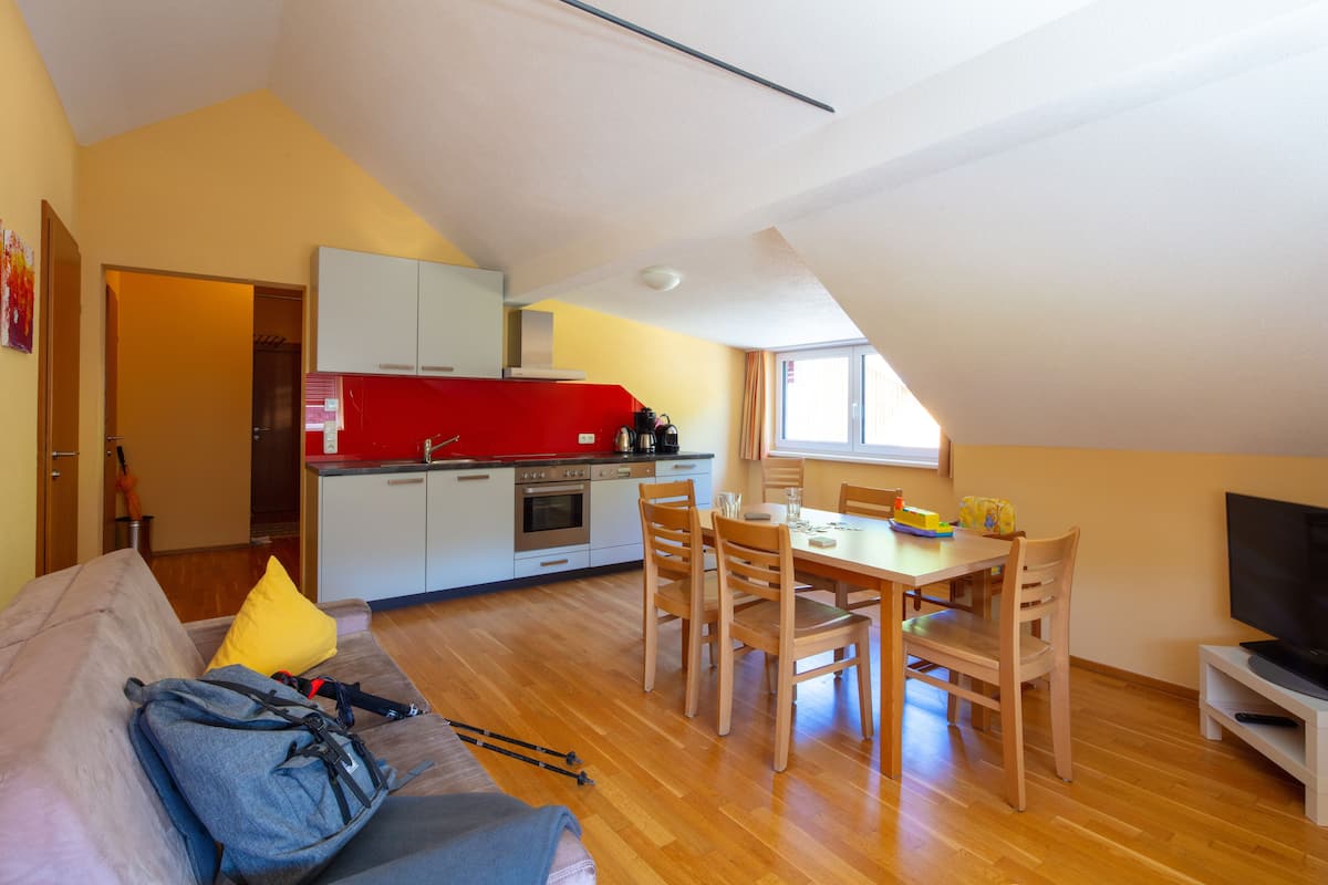 A compact living space with a kitchenette, a dining area, and a seating area.