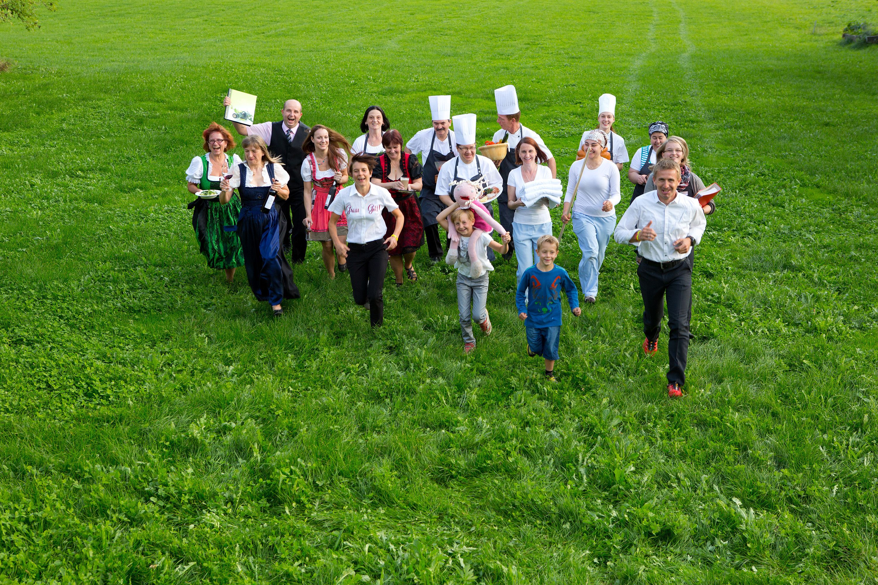 A group of people in a grassy field, some wearing chef hats.