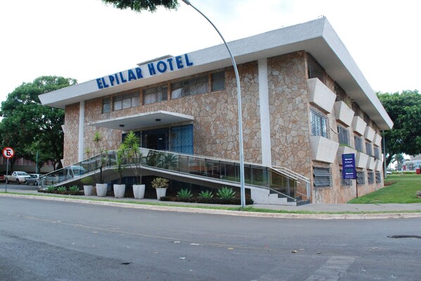 The El Pilar Hotel with a stone facade, a covered entrance, and a staircase leading to the entrance. - Hotel El Pilar by Bsb Inn (Brasília)