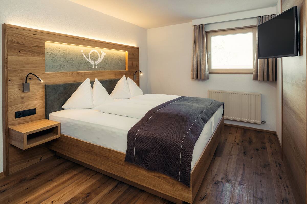 Ropa de cama hipoalergénica y caja de seguridad en la habitación