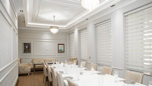 Une salle à manger avec une longue table dressée pour le repas, entourée de chaises.