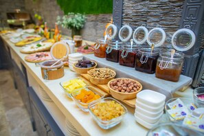 A buffet table with various food items and condiments. - GRAND HOTEL BAKU CENTRAL PARK (Baku)