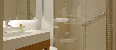 A modern bathroom with a glass-enclosed shower, a white sink, and a mirror above it.
