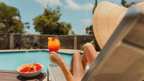 A person relaxing by a pool with a drink and a bowl of fruit. - Hyatt Place Bayamon (Bayamon)