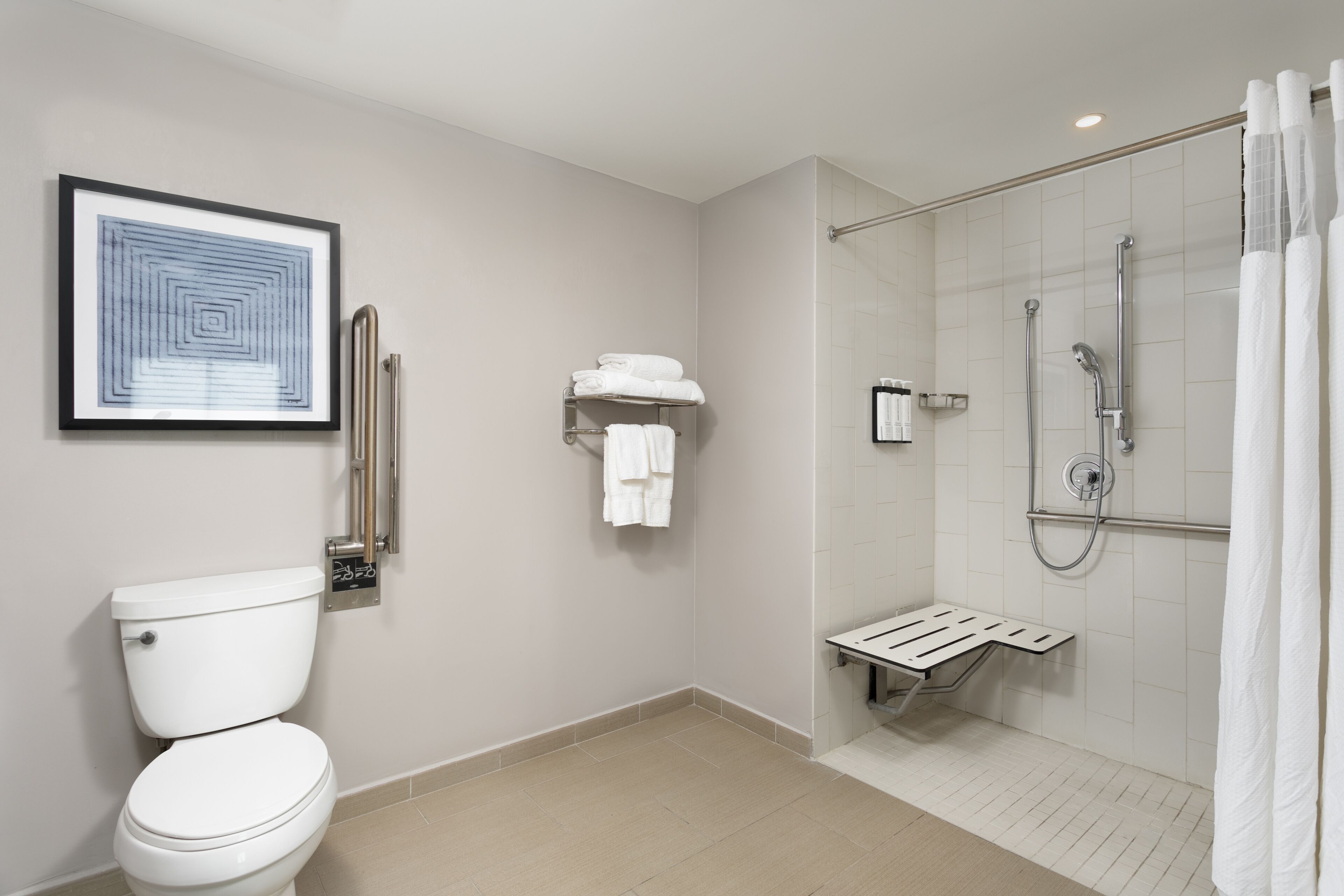 A modern bathroom with a toilet, a shower with a glass door, and a towel rack.