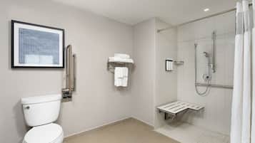 A modern bathroom with a toilet, a shower with a glass door, and a towel rack.
