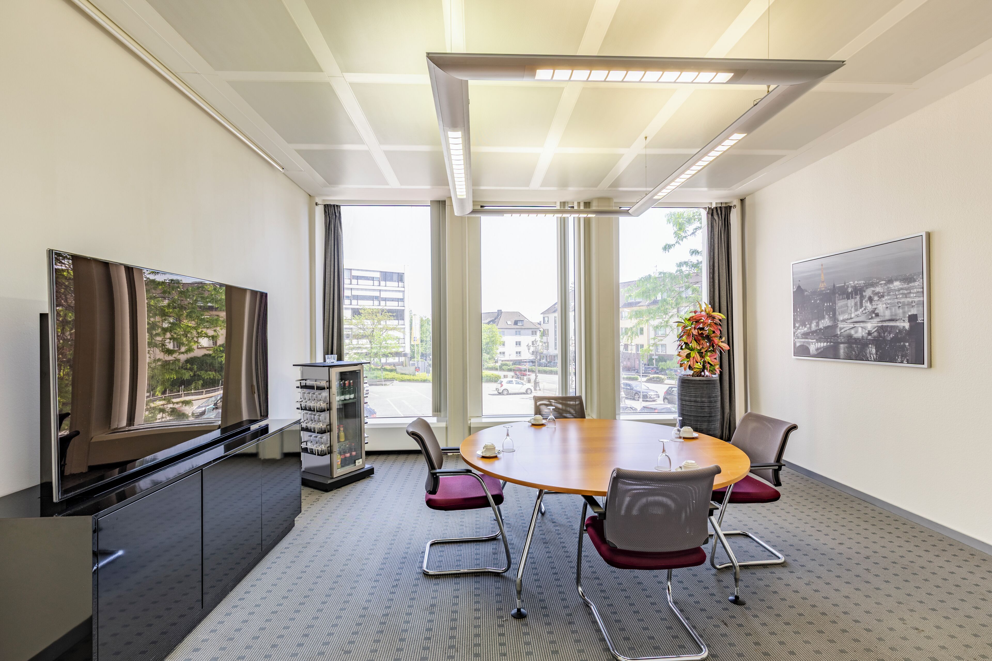 A conference room with a large table, chairs, a television, and a vending machine.