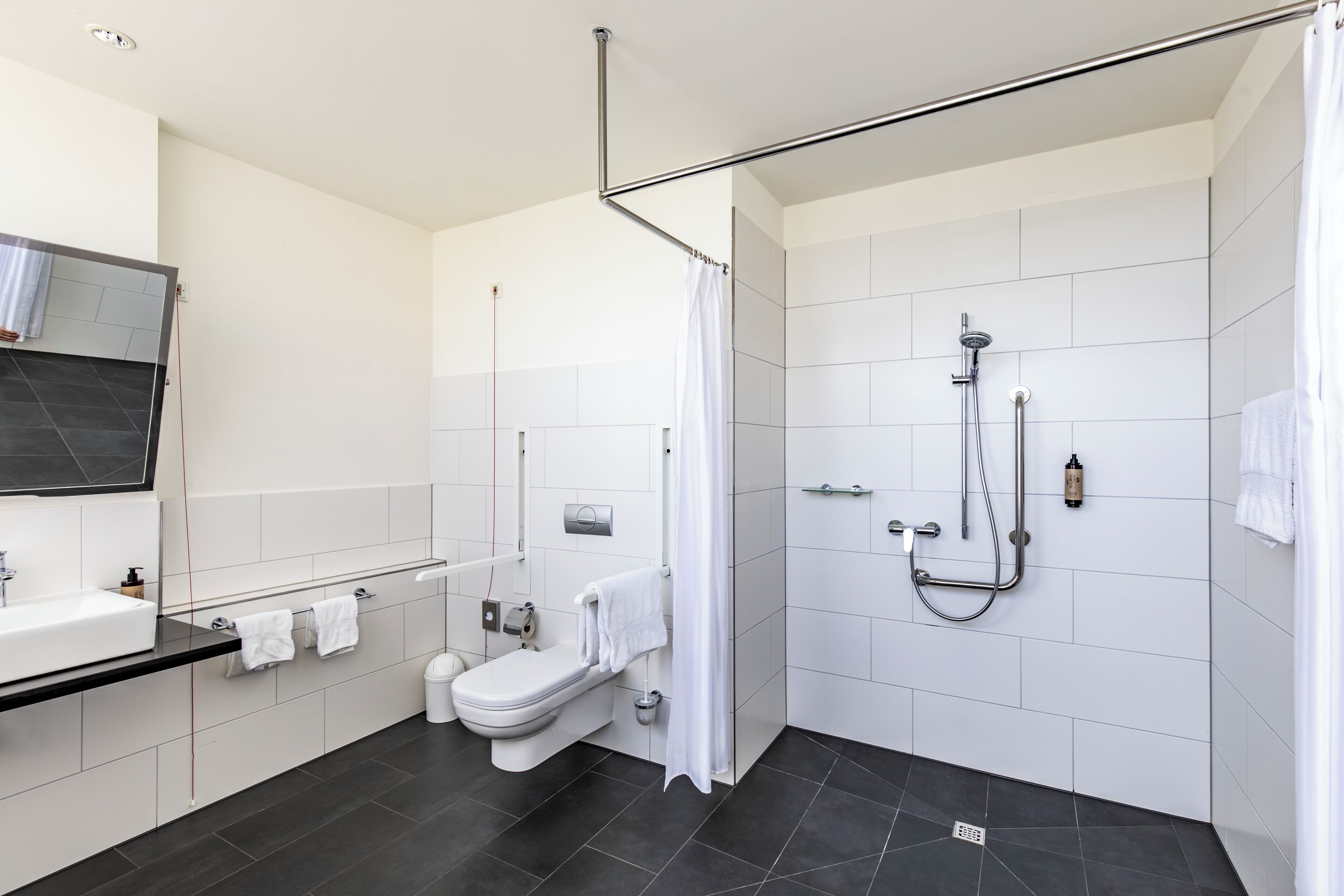 Ein modernes Badezimmer mit Dusche, Toilette und Waschbecken.