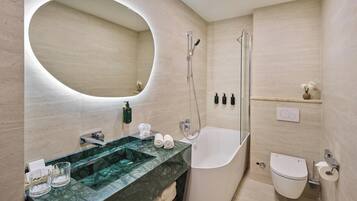 A modern bathroom with a freestanding bathtub, a large mirror, and a marble sink.