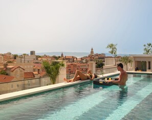 A rooftop pool with a clear view of the cityscape, including buildings and a distant tower. - Palazzo President (Split)