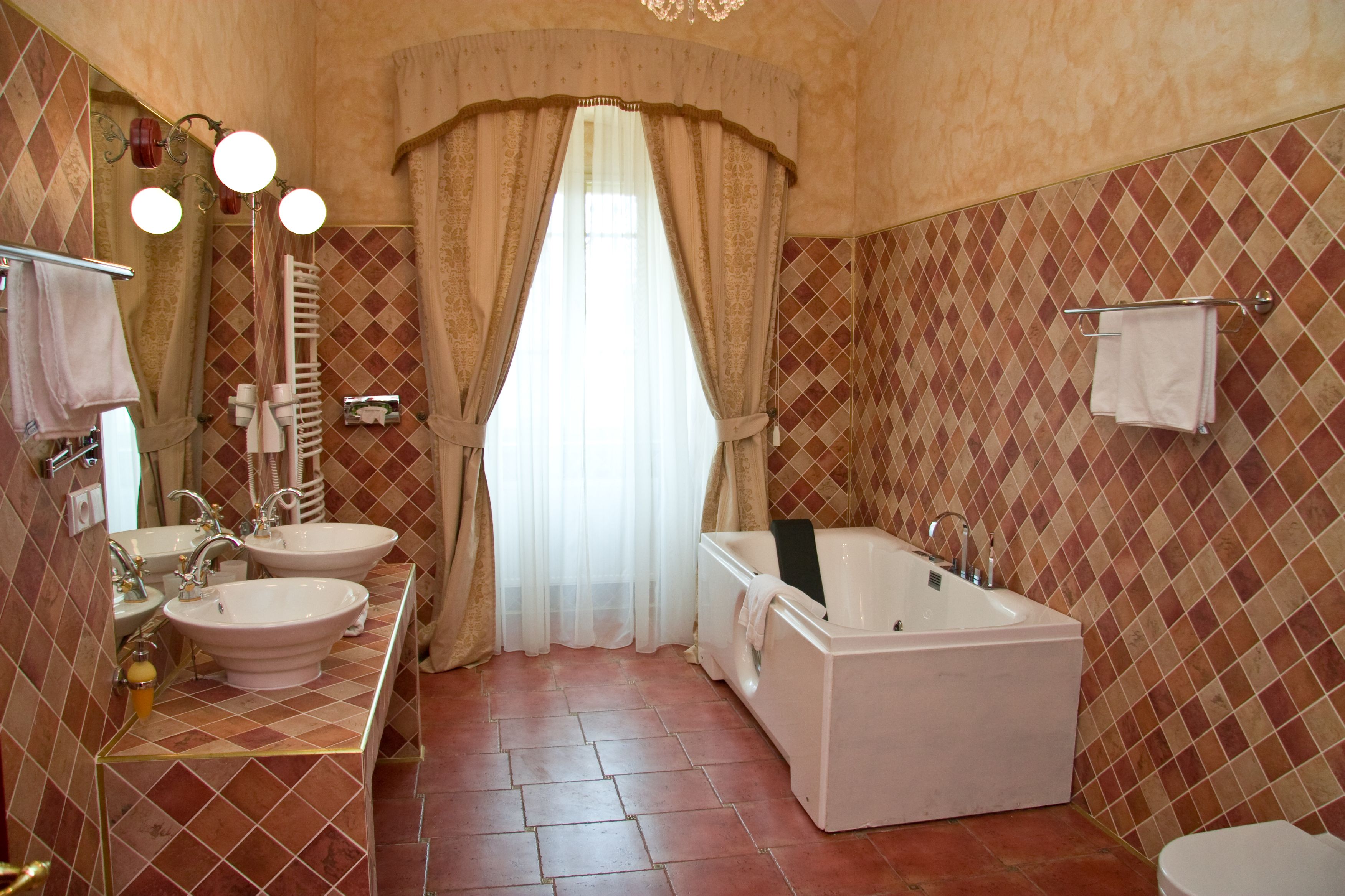 Une salle de bain avec deux lavabos, une baignoire et des toilettes.