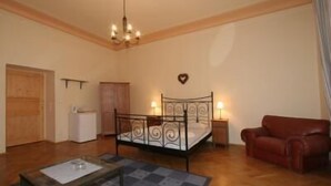 Un dormitorio con cama, escritorio, silla, armario y candelabro.