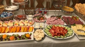 Un bufé con diversos alimentos, entre ellos frutas, carnes y quesos.