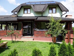 Un bâtiment à deux étages, doté d’un toit en pente, d’une façade en bois et d’un porche avant couvert.