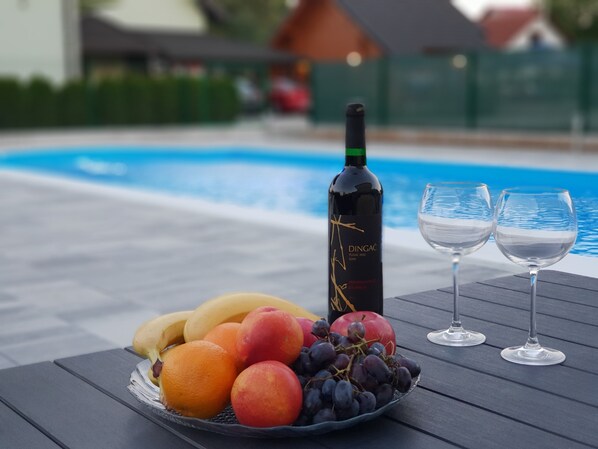 Una piscina al aire libre, sillones reclinables de piscina