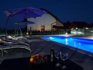 Una piscina al aire libre, sillones reclinables de piscina