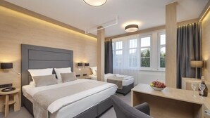 Una camera d'albergo moderna con un letto grande, una scrivania e una sedia.