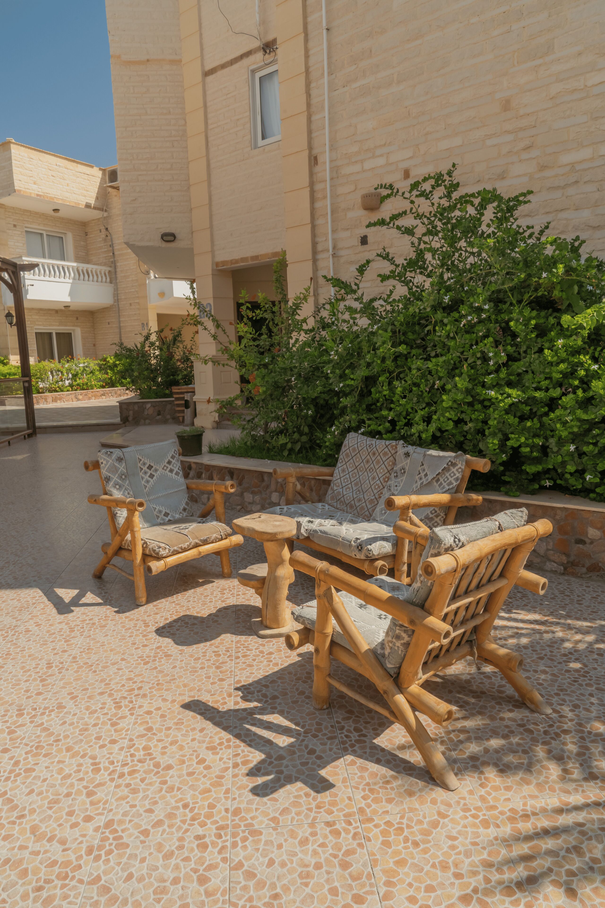 Un patio con mobiliario de madera y una pared de piedra.