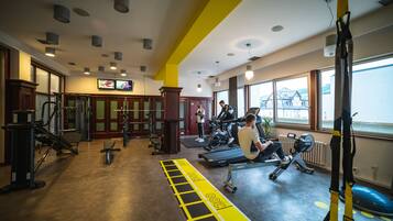 A gym with various exercise equipment, a treadmill, and a weight bench.