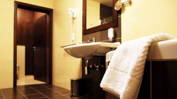 A bathroom with a sink, mirror, and towel rack.