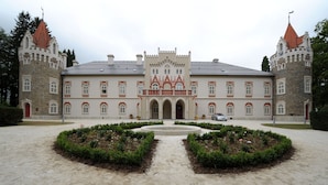A large, historic building with a central courtyard, symmetrical architecture, and a prominent tower with a clock. - Chateau Herálec Boutique Hotel & Spa by L'OCCITANE (Heralec)