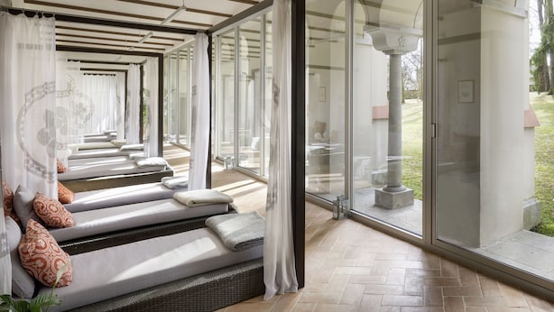 A spa area with multiple massage beds, a glass-enclosed space, and a view of the outdoors. - Chateau Herálec Boutique Hotel & Spa by L'OCCITANE (Heralec)